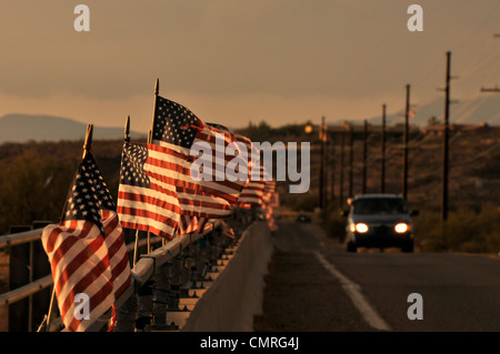 Drapeaux américain attaché à un pont au-dessus de la rivière de Santa Cruz dans le vent souffler à Green Valley, Arizona, USA. Banque D'Images