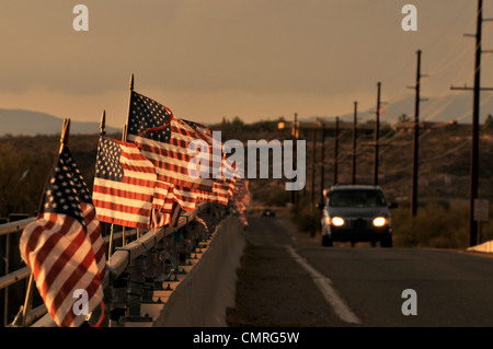 Drapeaux américain attaché à un pont au-dessus de la rivière de Santa Cruz dans le vent souffler à Green Valley, Arizona, USA. Banque D'Images