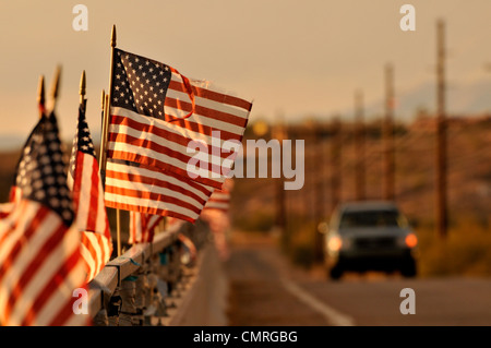 Drapeaux américain attaché à un pont au-dessus de la rivière de Santa Cruz dans le vent souffler à Green Valley, Arizona, USA. Banque D'Images