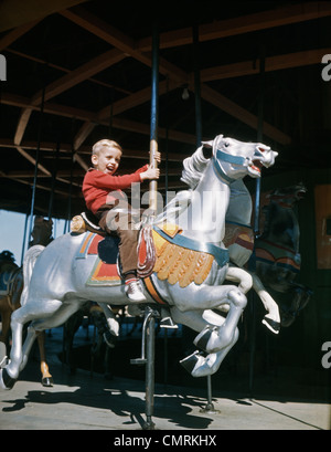 Années 1950, peu d'EXCITED BOY RIDING CAROUSEL en bois sculpté merry-go-ROUND CHEVAL À UN PARC D'CARNIVAL Banque D'Images