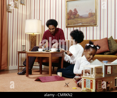 1970 AFRICAN-AMERICAN FAMILY Mère Père TABLE BASSE GIRL PLAYING Maison de poupée rétro de salon Banque D'Images