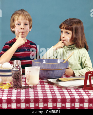 1970 1970 RETRO Garçon Fille FRÈRE SŒUR DES COOKIES CHOCOLAT PÂTE DÉGUSTATION Cuisine Cuisson Banque D'Images