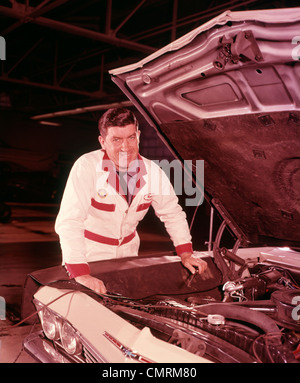 1960 MÉCANICIEN AUTOMOBILE COMBINAISONS BLANCHES 1960 CAPOT MOTEUR VOITURE TRAVAIL SOURIANT DE REMISE EN ÉTAT DU POSTE DE GAZ RETRO Banque D'Images