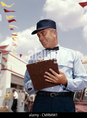 1960 MAN SERVICE MANAGER À UNE STATION-SERVICE WRITING ON CLIPBOARD GAS ET DE RÉPARATION PISCINE Banque D'Images