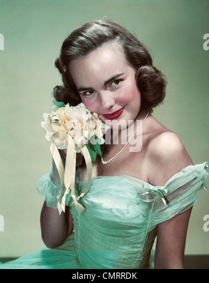 Années 1940 Années 1950 PORTRAIT SMILING WOMAN WEARING GREEN ROBE GOWN HOLDING BOUQUET NOSEGAY JAUNE Banque D'Images