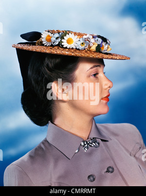 Années 1940 Années 1950 PROFILE PORTRAIT WOMAN WEARING Straw Hat costume gris avec des fleurs Banque D'Images