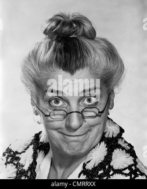 1970 portrait femme âgée avec des cheveux en chignon portant lunettes MAMIE SMILING AT CAMERA Banque D'Images