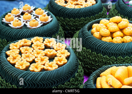 Une variété de desserts thaï joliment arrangés dans des bols fabriqués à partir de feuilles de bananier Banque D'Images