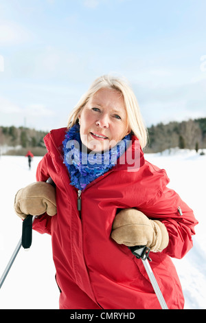 Femme appuyé contre ses bâtons de ski Banque D'Images
