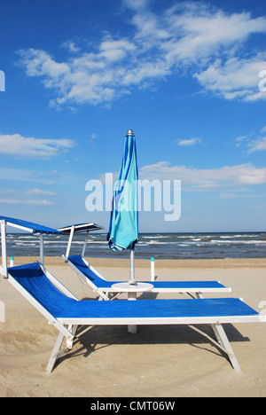 Chaises et parasol de plage bleu par la mer, à Rimini, Italie Banque D'Images