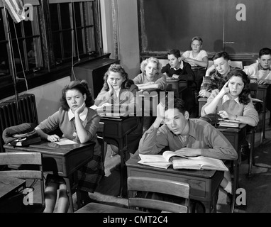 Années 1940 Années 1950 HIGH SCHOOL DE CLASSE D'ENNUYER LES ÉLÈVES ASSIS À UN BUREAU Banque D'Images