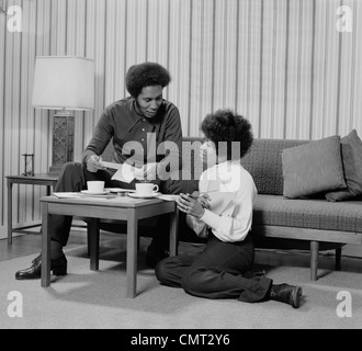 1970 AFRICAN AMERICAN COUPLE LIVING ROOM TALKING OVER COFFEE Banque D'Images