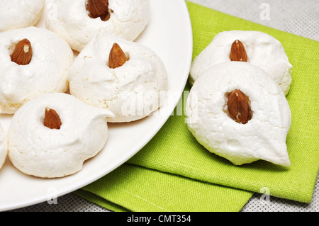 Des meringues aux amandes sur plaque blanche. Banque D'Images