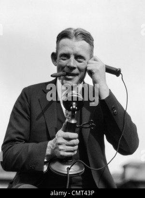 1920 PORTRAIT OF BUSINESSMAN TALKING ON PHONE CHANDELIER CIGARE FUMER À L'INTÉRIEUR DE BUREAU Banque D'Images