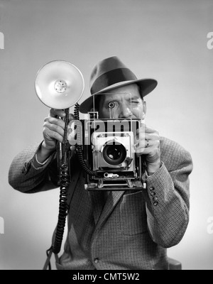 1950 Photographe de presse MAN HOLDING A 4X5 GRAPHIQUE VITESSE APPAREIL PHOTO AVEC UN FLASH PORTABLE Banque D'Images