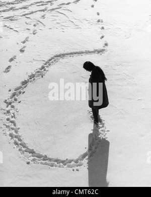 1970 VUE AÉRIENNE DE FEMME FAISANT LES VOIES CIRCULAIRES EN HIVER NEIGE OUTDOOR Banque D'Images