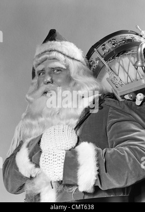 1940 PORTRAIT OF SANTA CLAUS AVEC UN SAC POUR DE JOUET PRÉSENTE SUR L'ÉPAULE LOOKING AT CAMERA Banque D'Images