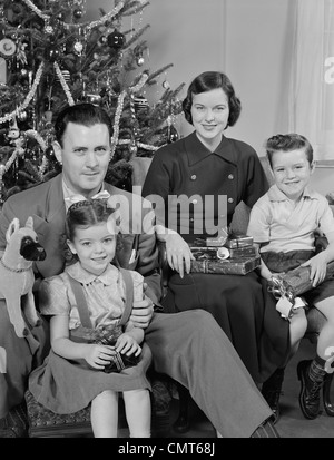 1950 Portrait de famille BY CHRISTMAS TREE LOOKING AT CAMERA Banque D'Images