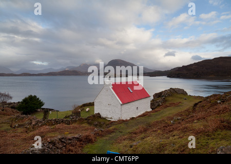 Un pittoresque crofters's cottage sur le côté du Loch Sheildaig donnant sur les montagnes de Torridon Banque D'Images