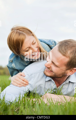 Heureux couple lying on grass Banque D'Images