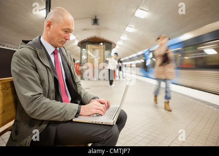 L'homme sur la plate-forme à l'aide d'ordinateur portable Banque D'Images