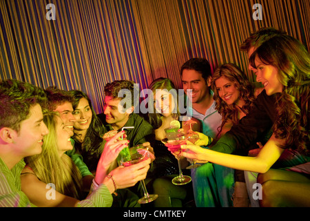 Amis hispaniques de boire des cocktails au bar Banque D'Images