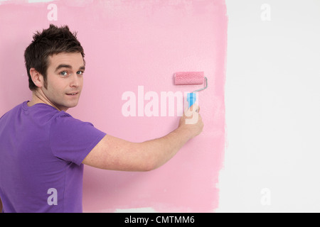 Jeune homme peinture décoration avec brosse rotative Banque D'Images