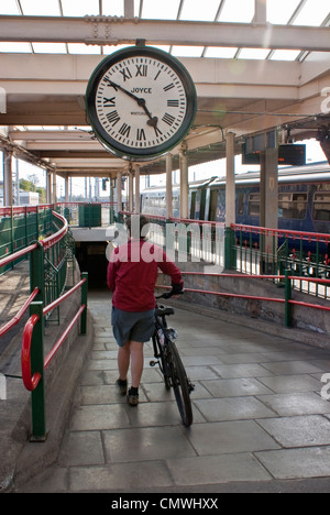 Femme avec vélo à Carnforth Lancashire la station. Station et réveil en vedette dans le film classique brève rencontre Banque D'Images
