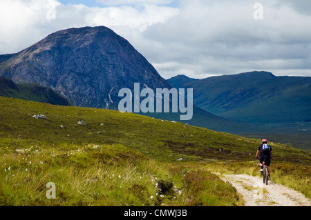 Le vélo de montagne sur le West Highland Way, Ecosse avec Buachaille Etive Mor derrière Banque D'Images