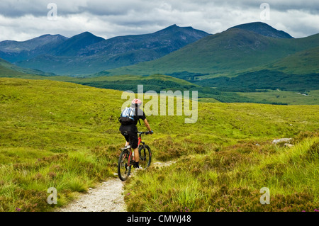 Le vélo de montagne sur le West Highland Way en Écosse, les pics de la montage à l'arrière noir Banque D'Images