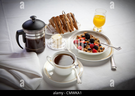 Petit-déjeuner continental avec des céréales et du pain grillé jus de café, disposés sur une nappe de lin blanc Banque D'Images