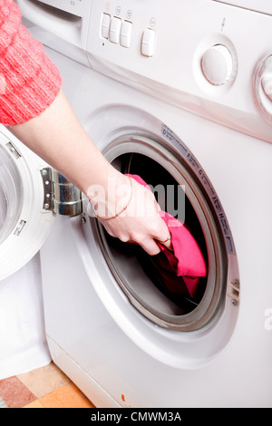 Jeune femme Chargement du lave-linge Banque D'Images