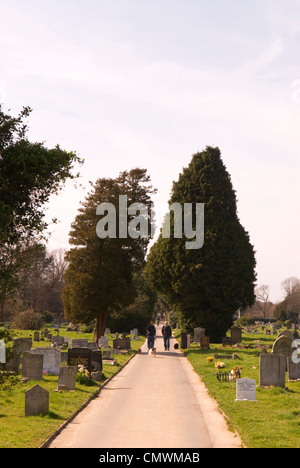 Les gens promènent leurs chiens le long chemin à Ann's Hill Cemetery, Gosport, Hampshire, Royaume-Uni. Banque D'Images