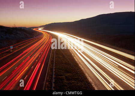 Sentiers de feux de circulation sur l'autoroute M6 dans la région de Cumbria sur une soirée d'hiver. Banque D'Images