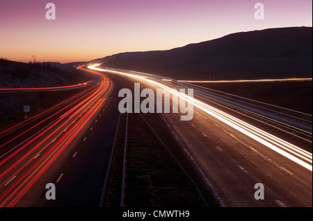 Sentiers de feux de circulation sur l'autoroute M6 dans la région de Cumbria sur une soirée d'hiver. Banque D'Images