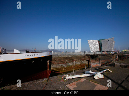 Le navire nomades se trouve en cale sèche avec le Titanic visitor centre à l'arrière-plan à Belfast, en Irlande du Nord Banque D'Images