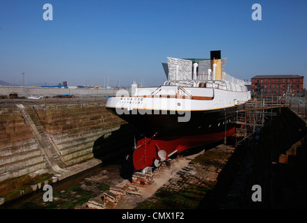 Le navire nomades se trouve en cale sèche avec le Titanic visitor centre à l'arrière-plan à Belfast, en Irlande du Nord Banque D'Images
