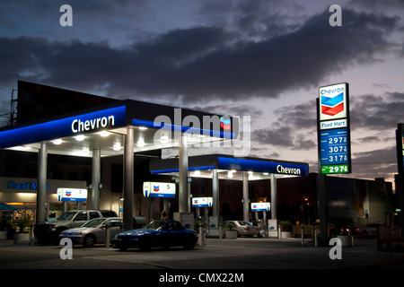 Chevron USA Gas Station sous moody ciel crépusculaire silhouette montrant des voitures à essence Banque D'Images