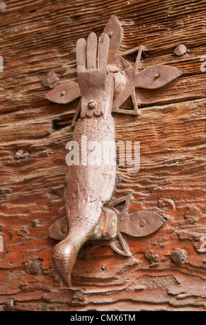 Ornate metal heurtoir ressemblant à un oiseau sur une vieille porte en bois lourd Banque D'Images