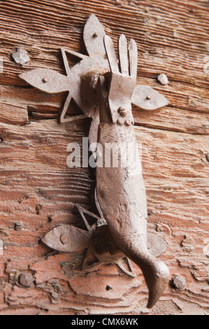 Ornate metal heurtoir ressemblant à un oiseau sur une vieille porte en bois lourd Banque D'Images