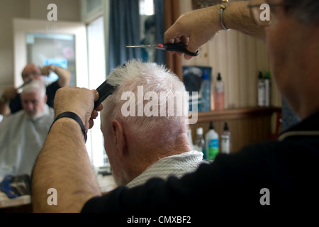 London, Ontario, Canada - le 28 mars 2012. Vincenzo Ioele de 'Vince's Barber Shop" s'occupe de client régulier George Stovel. Banque D'Images