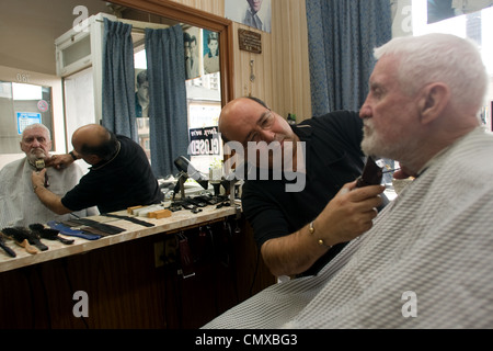 London, Ontario, Canada - le 28 mars 2012. Vincenzo Ioele de 'Vince's Barber Shop" s'occupe de client régulier George Stovel. Banque D'Images