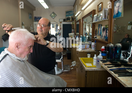 London, Ontario, Canada - le 28 mars 2012. Vincenzo Ioele de 'Vince's Barber Shop" s'occupe de client régulier George Stovel. Banque D'Images