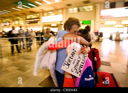 Famille réunis dans la zone d'arrivée à l'aéroport d'Heathrow Banque D'Images