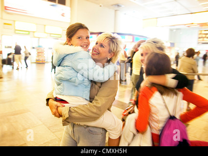 Famille réunis dans la zone d'arrivée à l'aéroport d'Heathrow Banque D'Images