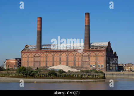 L'ancien lots road power station, vu de l'autre côté de la Tamise à Battersea, avec un chaland de charge en premier plan Banque D'Images