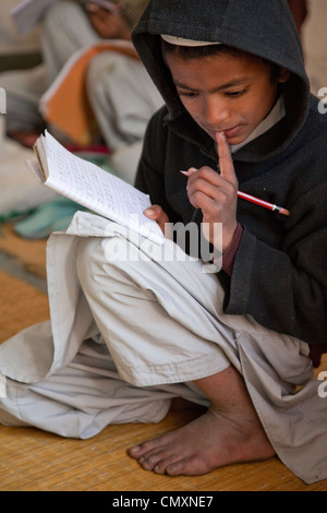 Considérant un étudiant Madrasa problème en classe, Madrasa Imdadul Uloom, Dehradun, Inde. Banque D'Images