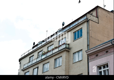 Un ancien bâtiment résidentiel beige, située à Prague, avec un petit bâtiment rose à sa droite. Banque D'Images