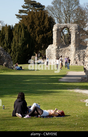 Le soleil brille, les adolescents parmi les ruines de l'ancienne abbaye, les jardins de l'abbaye de Bury St Edmunds, Suffolk, UK Banque D'Images