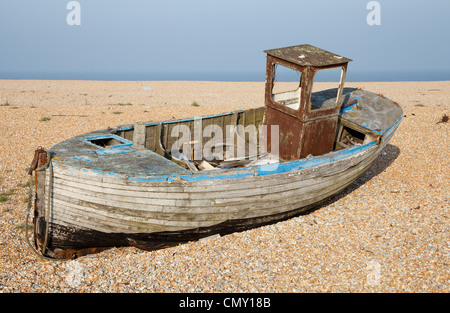 Vieux bateau de pêche en bois en mauvais état après des années de négligence sur la plage à Dungeness, dans le Kent, UK. Banque D'Images